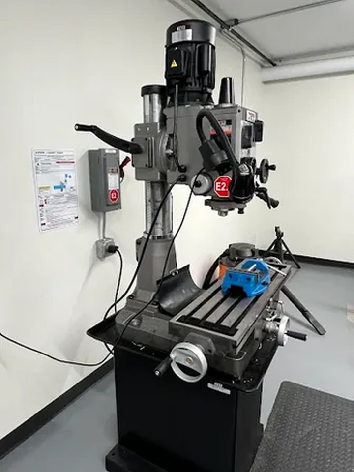 Machine-specific lockout point on a drill press with red lockout device installed