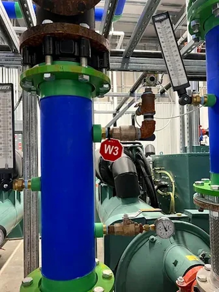 Industrial piping pneumatic valve lockout point with red padlock applied